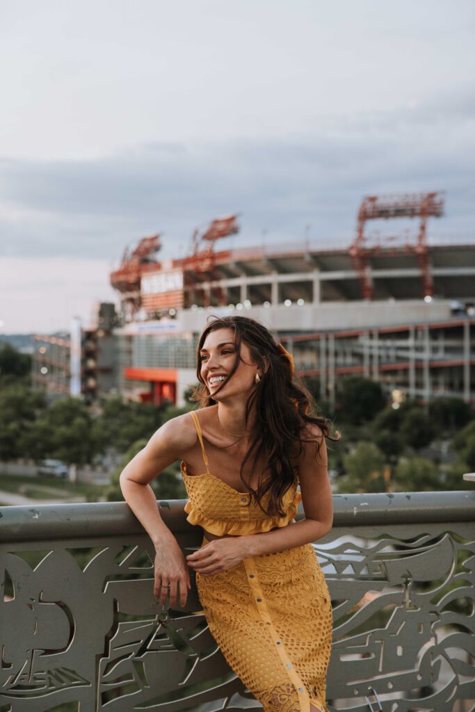 Woman in a yellow dress with a stadium in the background