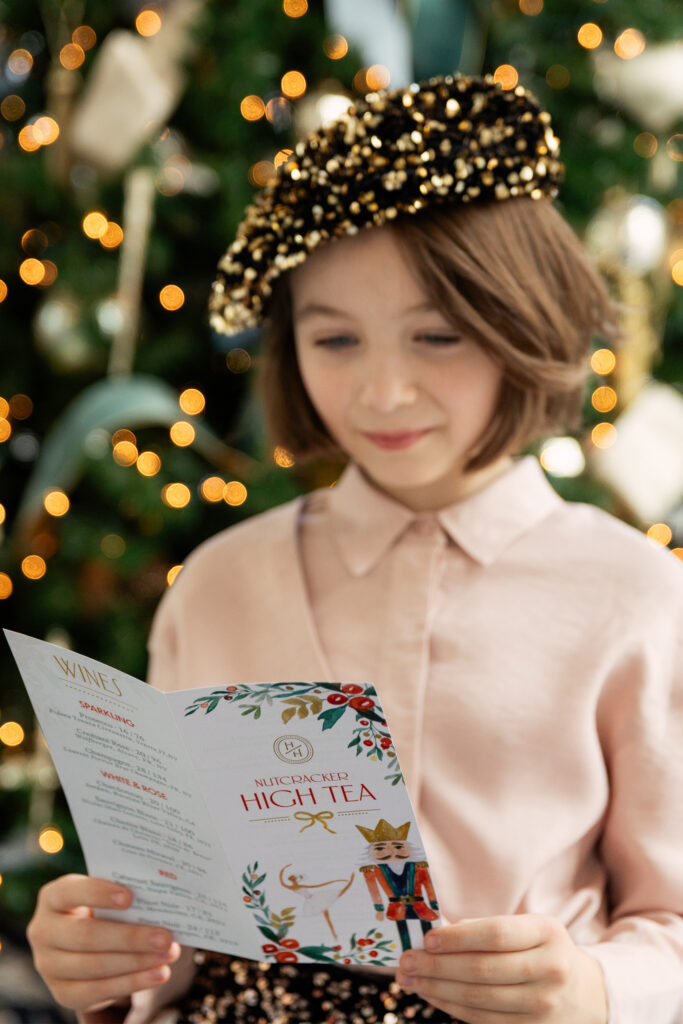 Young girl looking at a High tea menu