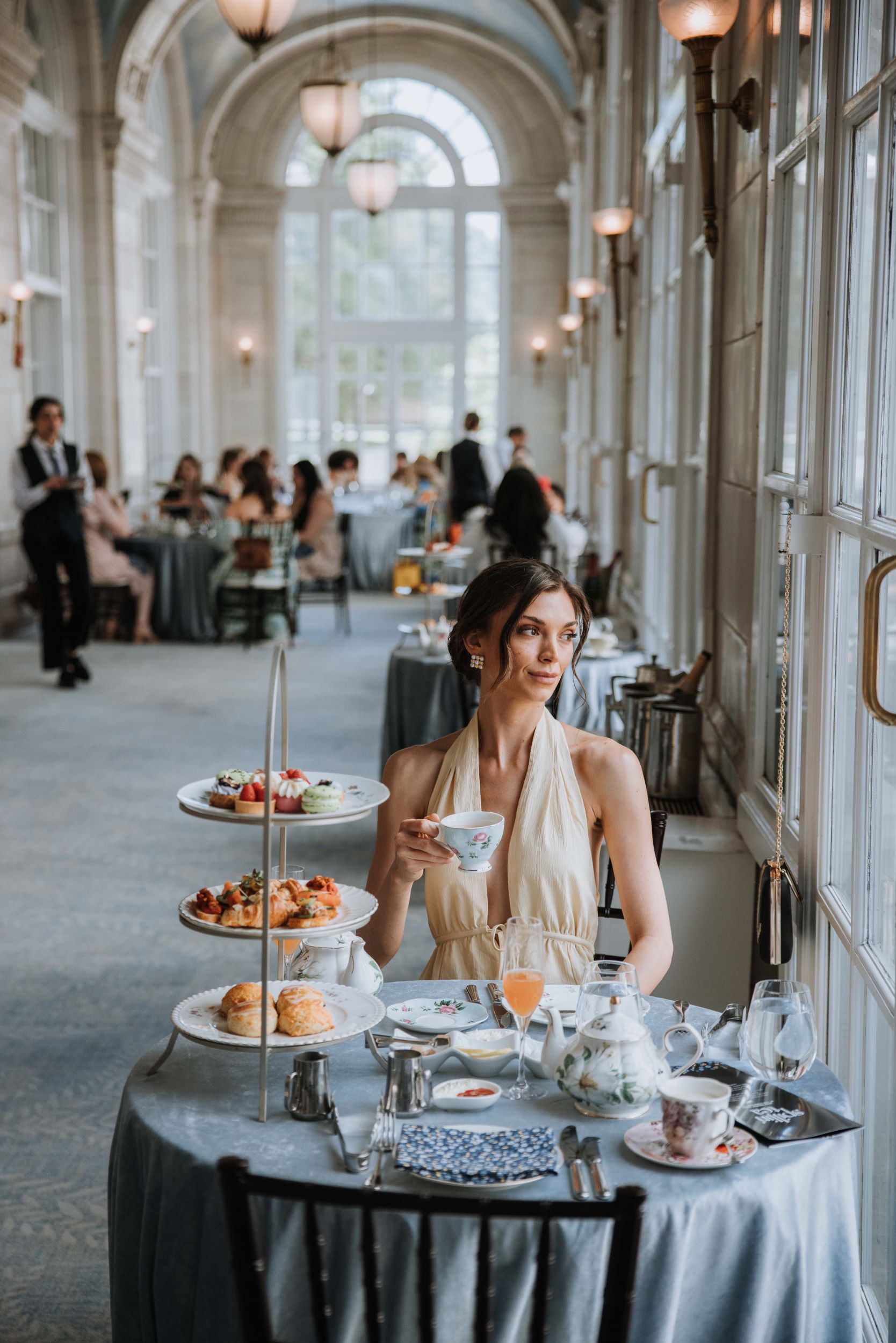 an elegantly dressed woman enjoying tea