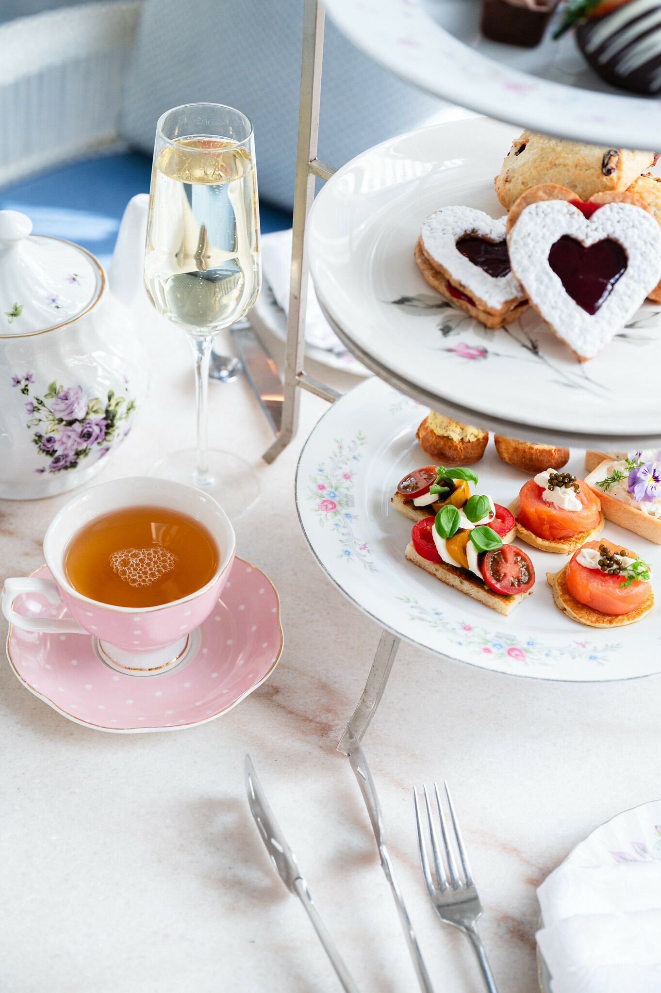 Afternoon tea with champagne, sandwiches, and heart-shaped pastries