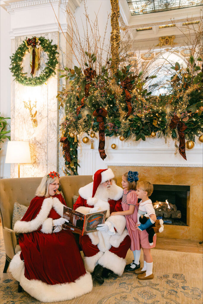 Santa and Mrs. Claus reading with two children.